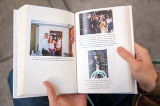 A person holds open pages of the book ‘Nobody’s Girl - A Memoir of Surviving Abuse and Fighting for Justice’ by Virginia Roberts Giuffre, displaying photos published in the book, as it is pictured in central London on 21 October 2025, on the day of its release in the UK